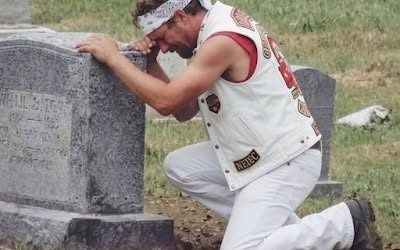 A biker showed up at my wife’s grave every week and I had no idea who he was. For six months I watched him from my car. Same day. Same time. Every Saturday at 2 PM he’d roll up on his Harley, walk to Sarah’s headstone, and sit there for exactly one hour. He never brought flowers. Never said a word that I could see. Just sat cross-legged on the ground next to her grave with his head bowed. The first time I saw him, I thought maybe he had the wrong grave. The cemetery’s big. People get confused. But he came back the next week. And the next. And the next. I started getting angry. Who was this guy? How did he know my wife? Why was he spending an hour every single week at her grave when some of her own family couldn’t be bothered to visit once a month? Sarah died fourteen months ago. She was forty-three. We’d been married twenty years. Two kids. A good life. A normal life. There was nothing in her past that would connect her to a biker. She was a pediatric nurse. She volunteered at church. She drove a minivan. Her idea of rebellion was putting an extra shot of espresso in her latte. But this guy, this biker, he was grieving her like he’d lost someone precious. I could see it in the way his shoulders shook sometimes. In the way he’d press his hand against her headstone before he left. It was driving me crazy. After three months, I couldn’t take it anymore. I got out of my car and walked over while he was there. He heard me coming. Didn’t turn around. Just kept his hand on Sarah’s headstone. “Excuse me,” I said. My voice came out harder than I meant it to. “I’m Sarah’s husband. Mind telling me who you are?” He was quiet for a long moment. Then he stood up slowly and said: “Your wife was my…… (continue reading in the C0MMENT)⤵️